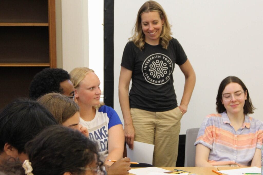Sarah Trone Garriott with students in a classroom for interfaith youth camp.
