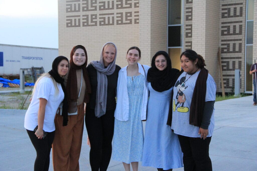 group of young girls smile outside of mosque.